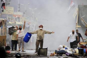 Manifestantes se encaran a las fuerzas de seguridad que intentan desalojar la acampada de los seguidores de Mursi en El Cairo (Egipto) (Foto: EFE )