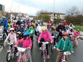 Un grupo de niños, con casco durante una marcha ciclista.