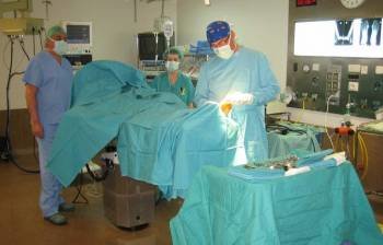 Un cirujano y su equipo realizan una intervención a un paciente en una sala de operaciones.