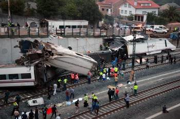 Voluntarios, agentes y servicios de emergencias, ante el tren accidentado, el 24 de julio. (Foto: VICENTE PERNÍA)