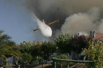 Una avioneta arroja agua en el incendio de A Merca (Foto: Marcos Atrio)