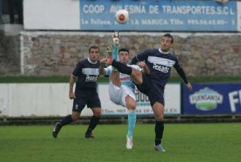 Gustavo Souto, delantero del Ourense, golpea el balón ante la presión de un defensor del Marino. (Foto: PALOMA UCHA)