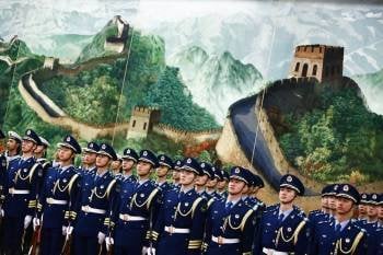 Militares en formación ante un mural de la Gran Muralla. (Foto: STRINGER.)