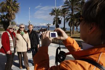 Un grupo de turistas hace una fotografía de recuerdo en su visita a una localidad costera.