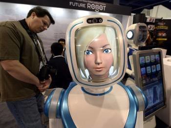 Un asistente observa un robot que ofrece un servicio inteligente las 24 horas, exhibido en el CES. (Foto: MICHAEL NELSON)