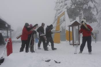 Un grupo de aficionados cargan con sus esquís camino de un  remonte para disfrutar de alguna de las 18 pistas abiertas ayer en Manzaneda. (Foto: MIGUEL ÁNGEL)