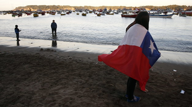 Una mujer sostiene la bandera de Chile 