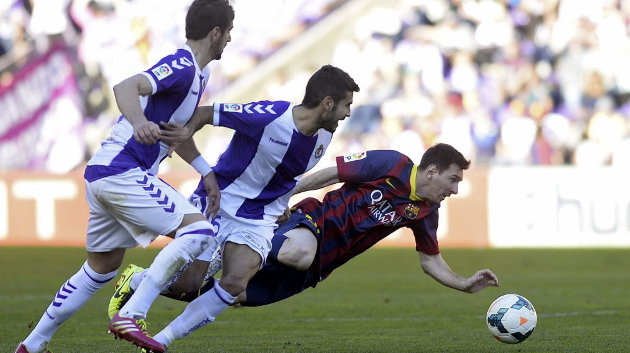  El delantero argentino del FC Barcelona Lionel Messi cae ante el centrocampista del Valladolid Lluís Sastre