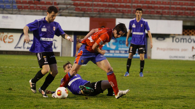 Adrián Cruz, trastabillado después de la entrada de un jugador de la UD Logroñés (MARCOS ATRIO)