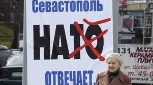 Una mujer pasa junto a un cartel contra la OTAN en Sebastopol (Z.KURTSIKIDZE)