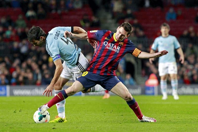 El delantero argentino del FC Barcelona Lionel Andrés Messi (d) lucha el balón con Borja Oubiña, del Celta de Vigo