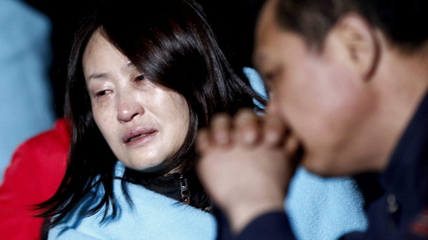 Una pasajera del buque Sewol se recupera en el puerto de Jindo tras ser rescatada