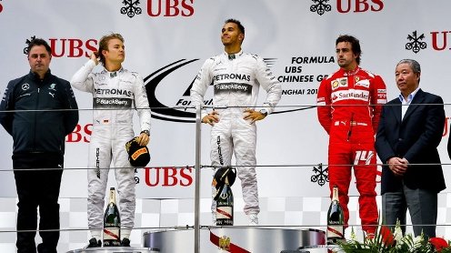 Lewis Hamilton, en el centro, escucha el himno británico como ganador del GP de China de Fórmula 1