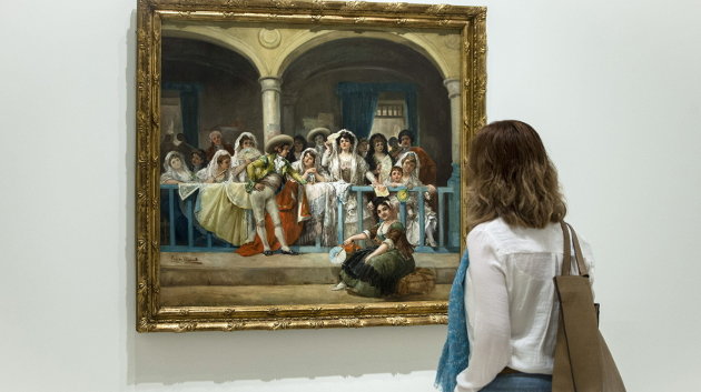 Una mujer observa el cuadro del pintor Eugenio Lucas Villaamil titulado &#34;En el Palco&#34;