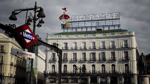 Vista de la madrileña Puerta del Sol con el cartel de Tio Pepe que se ha instalado esta noche en lo alto del número 11, tres años después de su retirada
