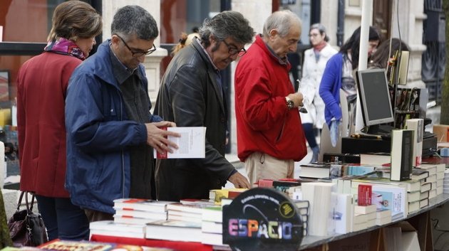 Unos lectores ojean los libros expuestos en el expositor de la librería del centro comercial PAseo (XESÚS FARIÑAS) 