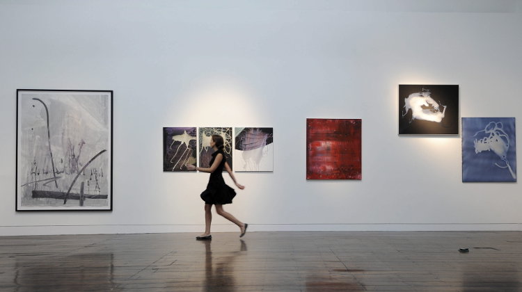 Una empleada de la casa de subastas Christie&#39;s pasa junto a obras de los artistas alemanes Sigmar Polke y Gerhard Richter expuestas en la sede de Christie&#39;s en Londres