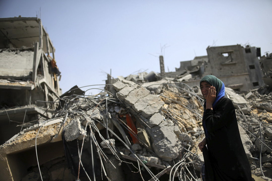 Una mujer palestina de la famila Al Kafarna llora mientras revisa su casa destruida por los bombardeos en la localidad de Beit Hanun, en el norte de la franja de Gaza
