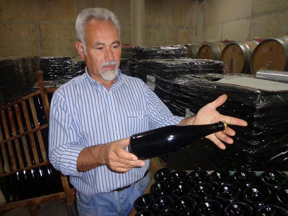 Rogelio Moral muestra una botella del primer espumoso tinto de Galicia.