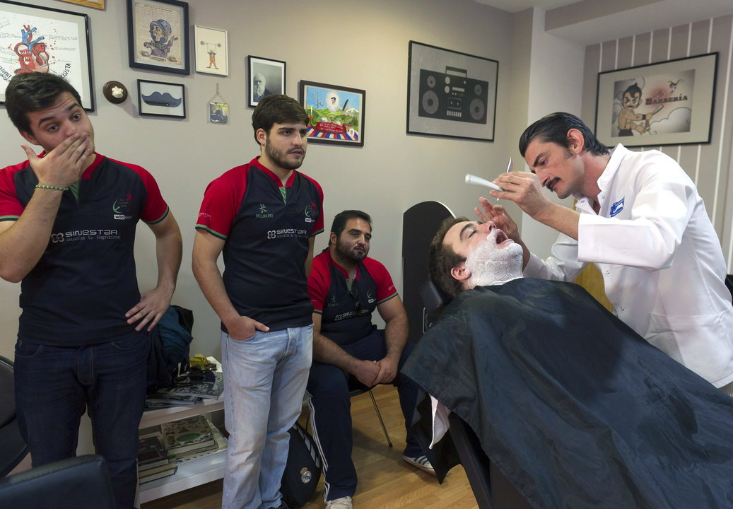 Jugadores del equipo de rugby Granada 2004 esperan, con barba de unos días, a ser afeitados
