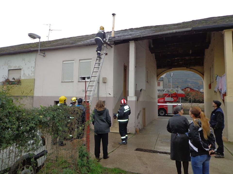 Un bombero accede al tejado de la vivienda.