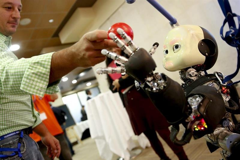 Un visitante interactúa con uno de los robots de la decimocuarta edición del congreso de robots humanoides más importante del mundo