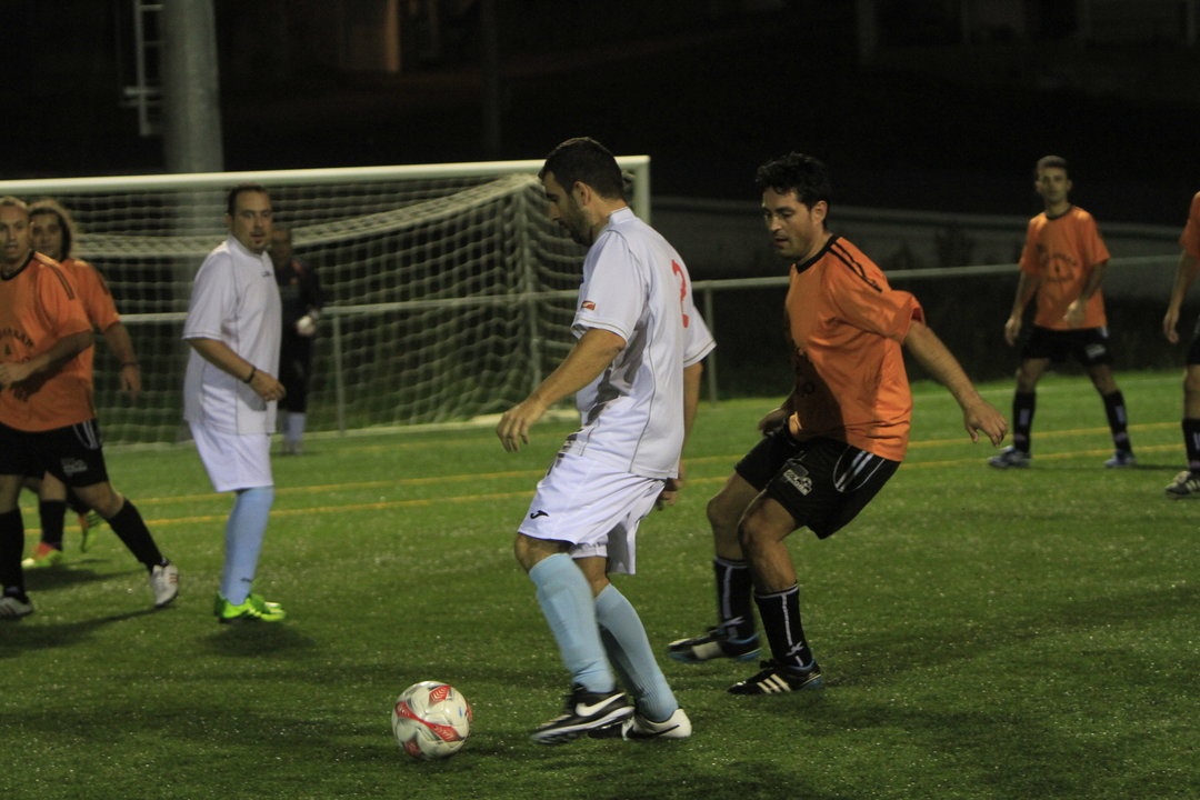 Uno de los jugadores conduce el balón ante la presencia de un rival.
