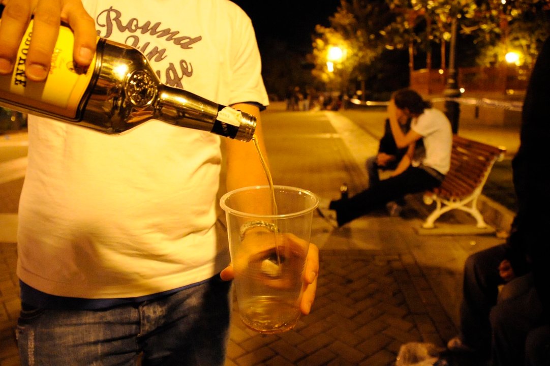 Un joven bebe alcohol en un botellón.