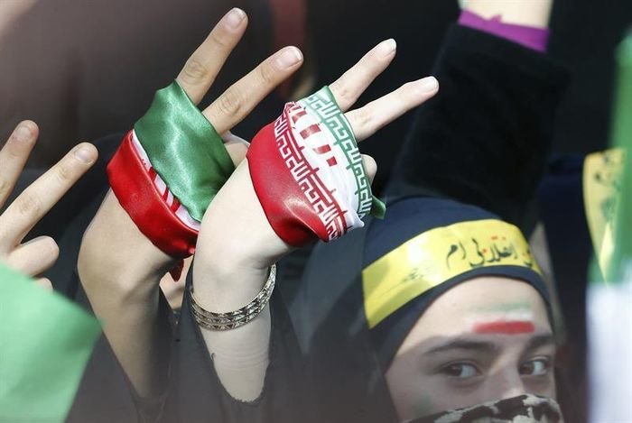 Estudiantes iraníes forman el símbolo de la victoria con sus manos durante una ceremonia por el 37º aniversario del triunfo de la Revolución Islámica.