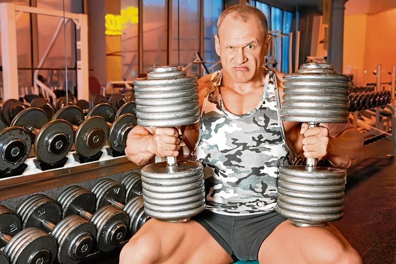 strong bodybuilder training muscles in gym
