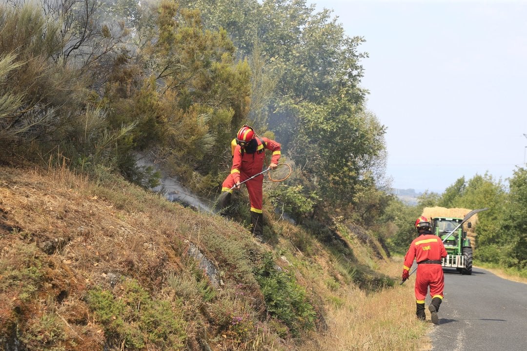 Dos militares de la UME, ayer en la ladera de un monte quemado en Castro Caldelas.