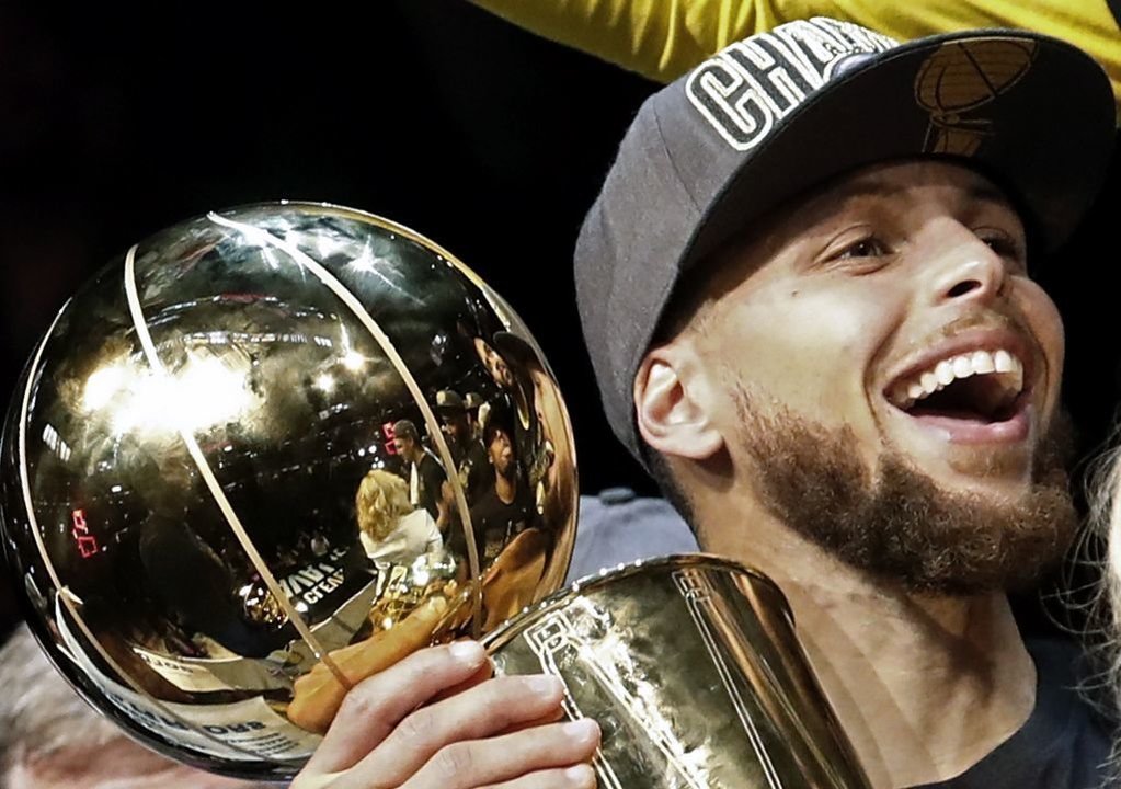 Curry, que anotó 37 puntos anoche, disfruta con el trofeo de campeón.