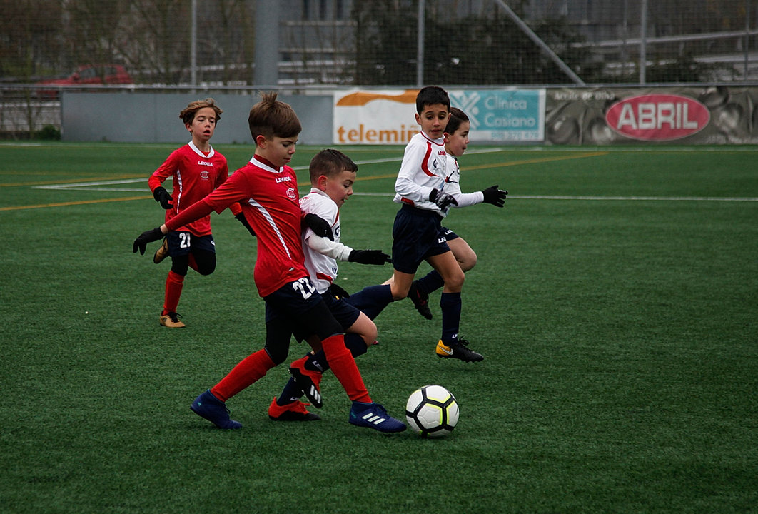 Dos jugadores, uno del Calasancio y otro de la ED Ourense, disputan un balón.