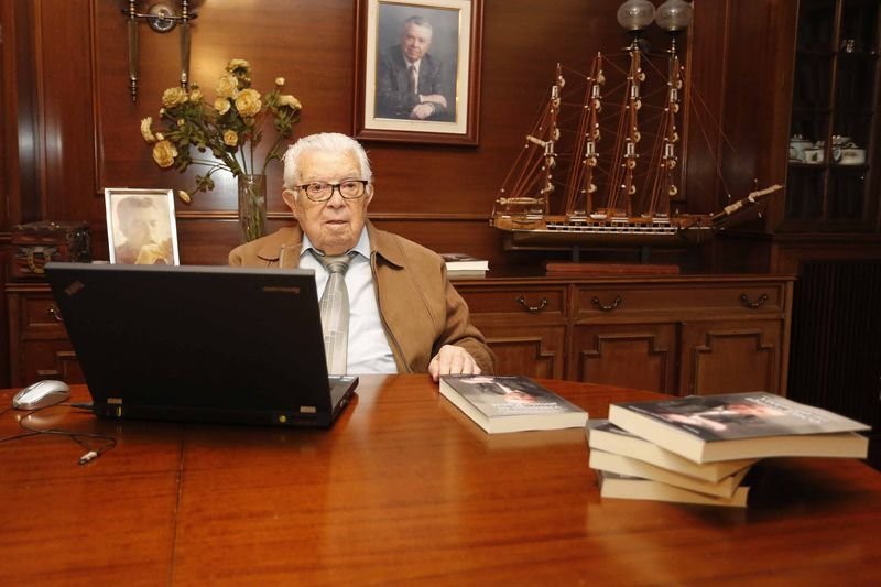 Paco Sabucedo, trajeado para la ocasión en su mesa, con el ordenador de sus rutinas, en Vigo (MARTA VÁZQUEZ).