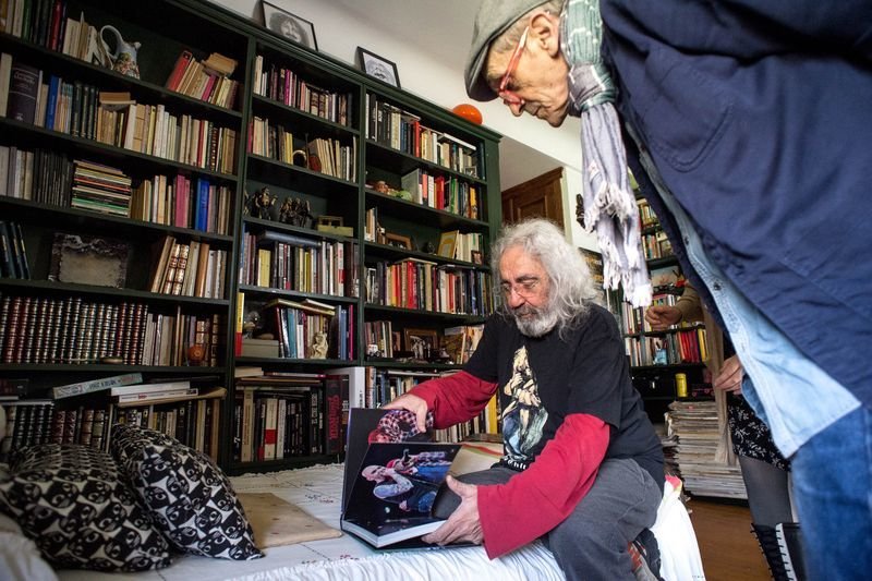 Yosi muestra las fotografías de un libro sentado en su vieja cama de crío (ÓSCAR PINAL).