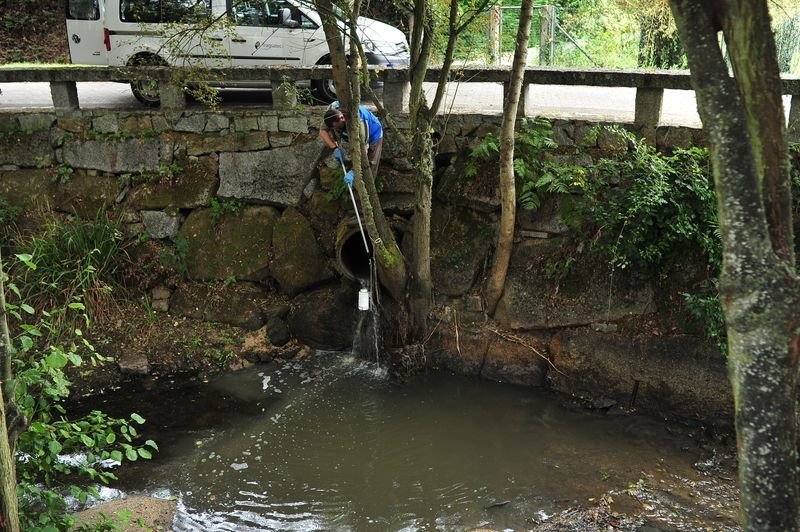Un operario de Viaqua limpia la zona afectada del río Dos Muiños por el vertido del pasado sábado.