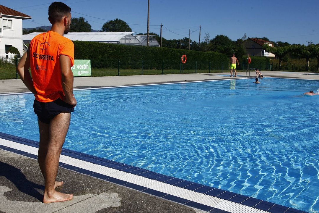 El socorrista de la piscina de Maceda observa ayer a los primeros bañistas (MIGUEL ÁNGEL).