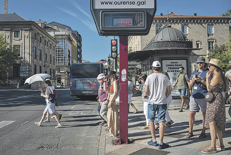 Turistas con sombreros y sombrillas, ayer en la ciudad de Ourense, donde se registraron más de 35 grados.