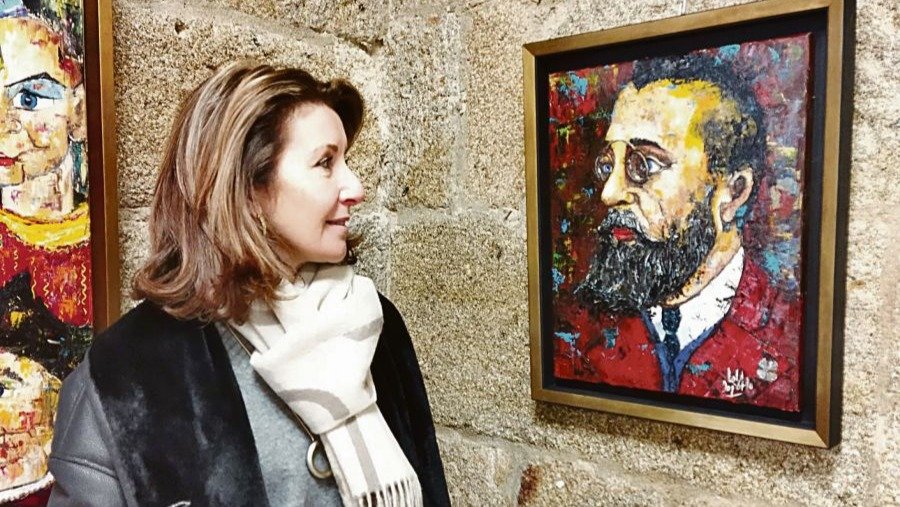 Lola Doporto frente al retrato de Curros Enríquez, en Celanova.