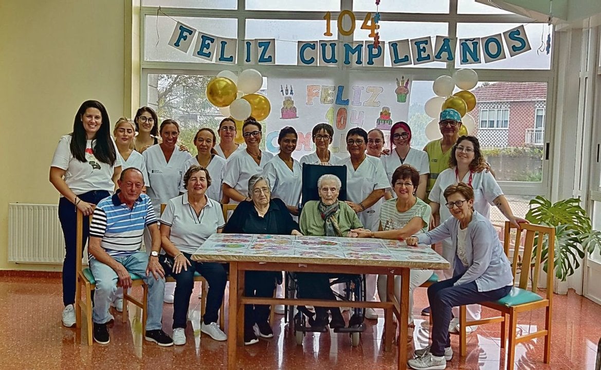 Foto de Genoveva -en silla de ruedas, en el centro- con las trabajadoras de la residencia de la Fundación San Rosendo en Cartelle, en una imagen para el recuerdo.