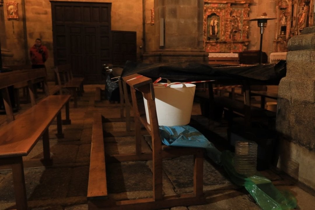 Cubos y plásticos tratan de recoger el agua que se filtra al interior del templo parroquial.