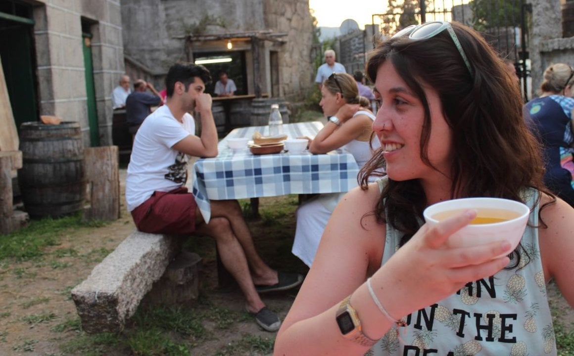 Una mujer disfruta de un vino en un furancho gallego.