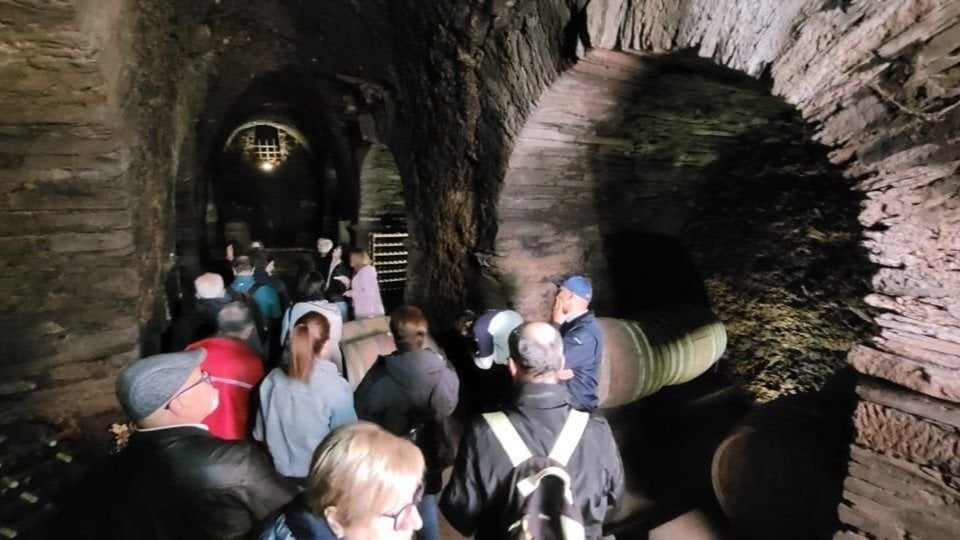 Un grupo de visitantes en una cova característica de Valdeorras.