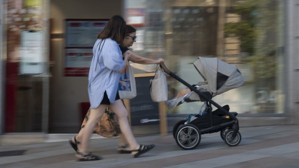 Dos mujeres pasean un bebé en el centro de la ciudad (Foto: Martiño Pinal).