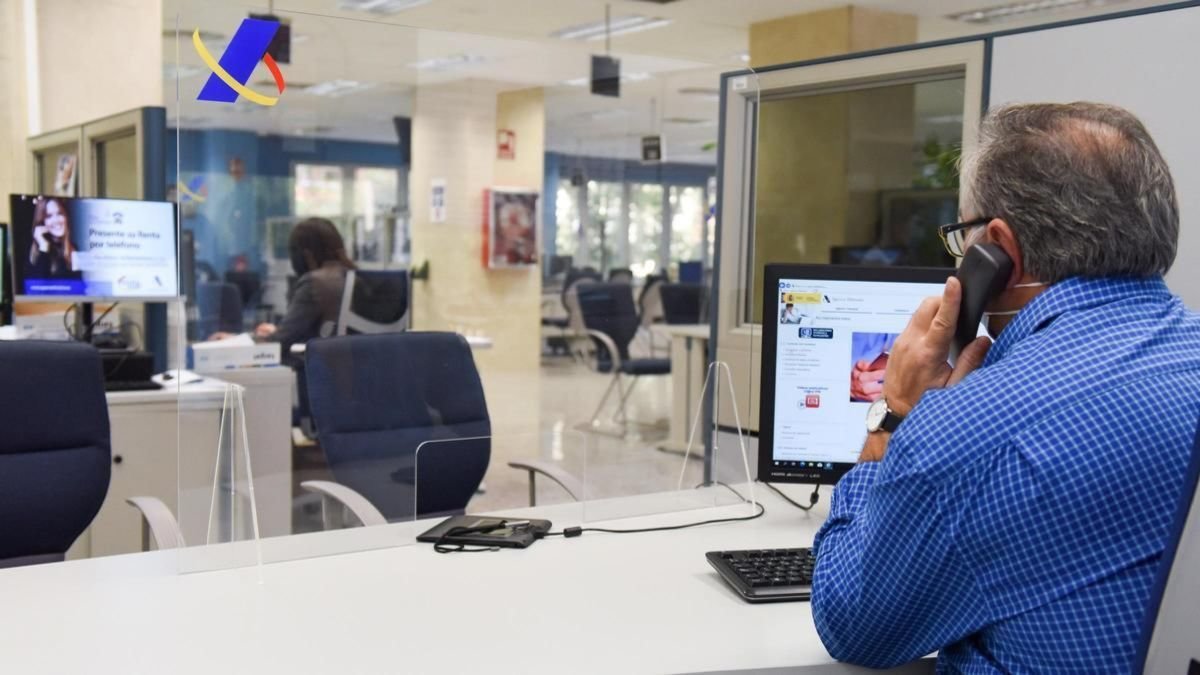Un empleado público atiende al teléfono en una oficina de Hacienda de Madrid.