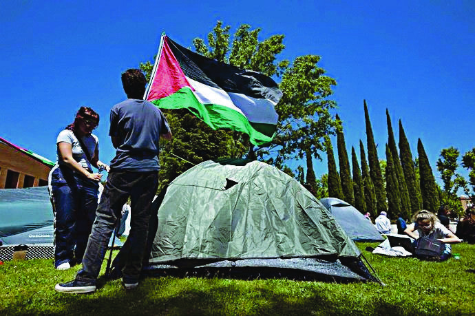 Dos estudiantes ponen una bandera palestina en señal de apoyo.