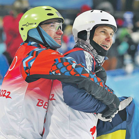 El esquiador ruso Ilia Burov abraza al ucraniano Oleksandr Abramenko en Beijing 2022. AGENCIAS