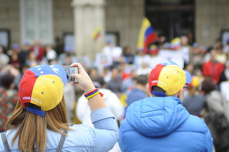 Dos personas graban una de las últimas manifestaciones de venezolanos en la ciudad.