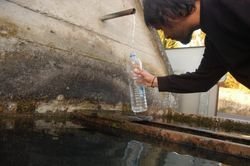 Un veciño de Razamonde recolle auga na fonte pública, na tarde de onte.