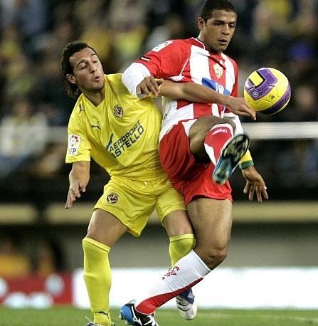 Santi Cazorla (izda) lucha por un balón con el jugador del Almería José María Ortiz.